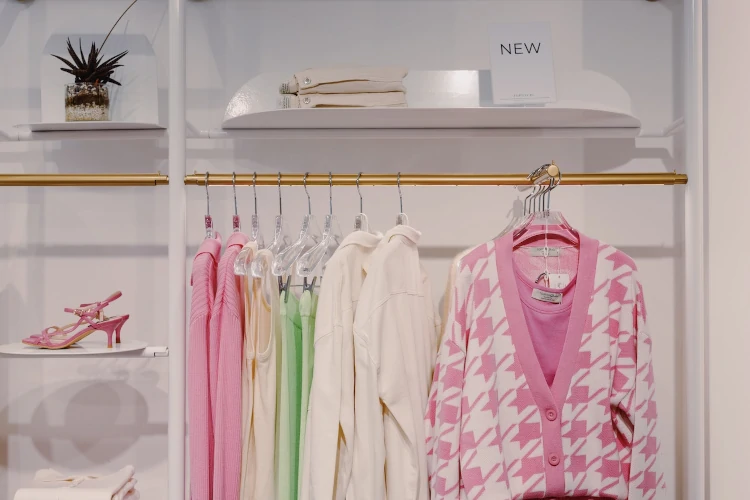 A pink and white jacket hanging in front of other clothes.